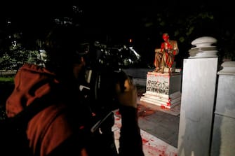 A statue dedicated to Italian journalist Indro Montanelli is smeared with red paint, with the words 'Racist, rapist' written on the base, at the homonymous garden in via Palestro in the center of Milan, Italy, 13 June 2020. 
ANSA/Mourad Balti Touati
