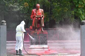 A municipal employee cleans a statue of a famous Italian journalist Indro Montanelli on June 14, 2020 in a Milan public square, a day after it was defaced, stained with red paint and tagged with the inscription "racist, rapist". - It is the first statue to be damaged in Italy since the wave of protests around the world triggered by the death of George Floyd in the US. (Photo by MIGUEL MEDINA / AFP)