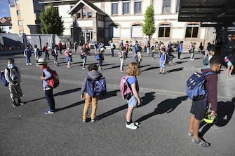 Children queue to enter their classrooms at the Ziegelau elementary school in Strasbourg, eastern France, as primary and middle schools reopen in France on June 22, 2020. - After six weeks of unsteady school sessions and more than three months of class at home to fight against the spread of the new coronavirus Covid-19, French pupils and middle school students return to class on June 22, thanks to a lighter health protocol. (Photo by FREDERICK FLORIN / AFP) (Photo by FREDERICK FLORIN/AFP via Getty Images)
