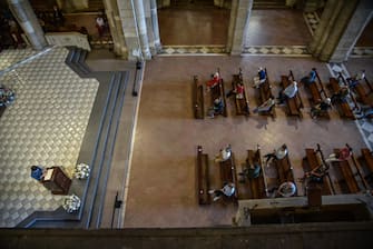 Il distanziamento tra le persone sedute sui banchi della basilica - La messa nella basilica di S.Ambrogio con il distanziamento personale e le norme anticontragio la prima domenica dopo l apertura dopo il lockdown per il coronavirus Covid19,  Milano 24 Maggio 2020  Ansa/Matteo Corner