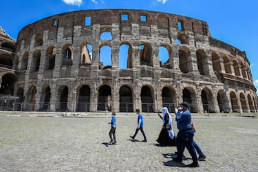 Tourists walk on June 22, 2020 by the Coliseum monument in Rome, as the country eases its lockdown aimed at curbing the spread of the COVID-19 infection, caused by the novel coronavirus. (Photo by Vincenzo PINTO / AFP) (Photo by VINCENZO PINTO/AFP via Getty Images)