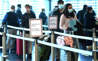 Flight passengers queue at a check in desk of the low-cost airline Wizz Air on May 1, 2020 at the Schwechat airport near Vienna, Austria. - Wizz Air is restarting flights from Vienna to 20 destinations over the coming weeks, with the first services running from Friday, May 1. The first destinations to be served would be Thessaloniki, Dortmund, Lisbon, Oslo and Eindhoven, the Hungary-based airline said in a statement, with other services restarting throughout the month of May. (Photo by HELMUT FOHRINGER / APA / AFP) / Austria OUT (Photo by HELMUT FOHRINGER/APA/AFP via Getty Images)