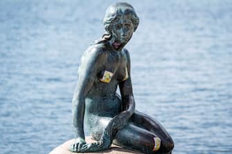 A picture taken on July 3, 2020 shows a view of the "Little Mermaid" sculpture after it has been vandalised with stickers and racist graffitis in Copenhagen. (Photo by Niels Christian Vilmann / Ritzau Scanpix / AFP) / Denmark OUT (Photo by NIELS CHRISTIAN VILMANN/Ritzau Scanpix/AFP via Getty Images)