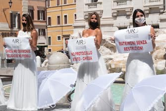 spose fontana di trevi roma manifestazione flash mob coronavirus A moment of the flash mob protest of brides in Trevi's fountain for the forced postponement of their marriages due to the covid19 coronavirus, Rome, 7 Jule 2020. ANSA/CLAUDIO PERI