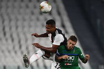 Juventus' Brazilian defender Alex Sandro (L) and Atalanta's Argentinian forward Papu Gomez go for a header during the Italian Serie A football match Juventus Turin vs Atalanta Bergamo played behind closed doors on July 11, 2020 at the Juventus stadium in Turin, as the country eases its lockdown aimed at curbing the spread of the COVID-19 infection, caused by the novel coronavirus. (Photo by Marco BERTORELLO / AFP) (Photo by MARCO BERTORELLO/AFP via Getty Images)