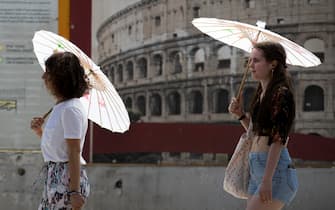 Ondata di caldo a Roma: due ragazze si proteggono dal sole con degli ombrelli. 29 giugno 2020 
ANSA/MASSIMO PERCOSSI
