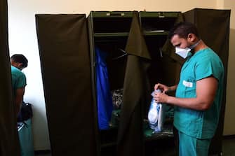 Cuban Doctor Roberto Arias Hernandez, specialized in internal medicine, prepares to put on personal protective equipment (PPE) prior going to work at the Maggiore Hospital of Crema, southeast of Milan, on May 15, 2020 during the country's lockdown aimed at curbing the spread of the COVID-19 infection, caused by the novel coronavirus. (Photo by MIGUEL MEDINA / AFP) (Photo by MIGUEL MEDINA/AFP via Getty Images)