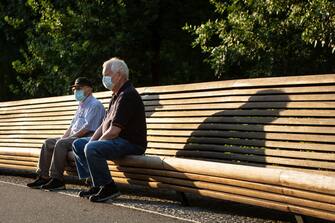 MADRID, SPAIN - MAY 26: Two seniors wearing protective face masks take a rest on a bench in the Madrid Rio park, which reopened during the so-called "Phase One" transition, after 72 days of it being closed due to the coronavirus crisis on May 26, 2020 in Madrid, Spain. All regions of Spain have now entered either Phase One or Phase Two of the transition from its coronavirus lockdown. This allows many shops to reopen as well as restaurants serving customers outdoors. Major metropolitan areas that were harder hit by coronavirus (Covid-19), such as Madrid and Barcelona, remain in Phase One. (Photo by Pablo Cuadra/Getty Images)