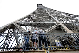 PARIS, FRANCE - July 15: Visitors wearing protective face masks look at the Paris city on the day of the reopening of the top floor of the Eiffel Tower on July 15, 2020 in Paris, France. After nearly three months of closure due to the coronavirus pandemic (COVID-19), the Eiffel Tower today opens its 3rd floor to the public. (Photo by Chesnot / Getty Images)