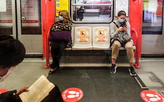 Commuters sit in a coach at the Cardona underground metro station, with red circles on the ground indicating where to stand to maintain distance, on May 4, 2020 in Milan, as Italy starts to ease its lockdown, during the country's lockdown aimed at curbing the spread of the COVID-19 infection, caused by the novel coronavirus. - Stir-crazy Italians will be free to stroll and visit relatives for the first time in nine weeks on May 4, 2020 as Europe's hardest-hit country eases back the world's longest nationwide coronavirus lockdown. (Photo by Miguel MEDINA / AFP) (Photo by MIGUEL MEDINA/AFP via Getty Images)