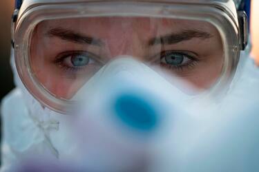 TOPSHOT - A medical worker wears protective goggles as she prepares to measure motorists' body temperatures  at the Slovenian-Italian border crossing near Nova Gorica, on March 11, 2020, after Slovenia's government announced it would close its border with Italy, hard hit by the outbreak of COVID-19, the new coronavirus. - Italy's neighbours Austria and Slovenia announced on March 10 Tuesday strict travel restrictions and other measures in the wake of similar moves by Rome to limit the spread of the new coronavirus. (Photo by Jure Makovec / AFP) (Photo by JURE MAKOVEC/AFP via Getty Images)