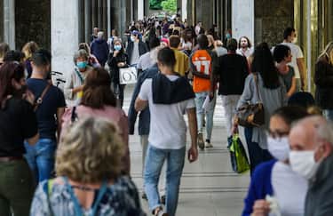Persone passeggiano e discutono sotto i portici di via Roma, Torino 19 maggio 2020 ANSA/TINO ROMANO