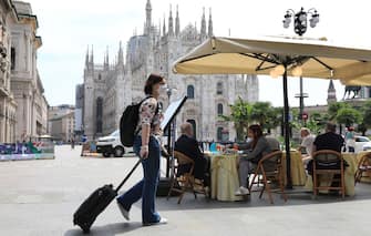 MILAN, ITALY - MAY 18:  People have drinks and food at a restaurant on Piazza del Duomo on the first day of opening after the lockdown on May 18, 2020 in Milan, Italy. Restaurants, bars, cafes, hairdressers and other shops have reopened, subject to social distancing measures, after more than two months of a nationwide lockdown meant to curb the spread of Covid-19. (Photo by Vincenzo Lombardo/Getty Images)