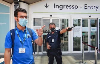 CATANIA, ITALY - JUNE 04: A passenger departing in front of the entrance of Catania airport is checked by a security officer on June 04, 2020 in Catania, Italy. Many Italian businesses have been allowed to reopen, after more than two months of a nationwide lockdown meant to curb the spread of Covid-19. (Photo by Fabrizio Villa/Getty Images)