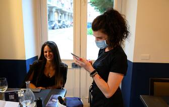 VINOVO, ITALY - JUNE 04: A waitress with protective mask at work during the reopening to the customers of a restaurant on June 04, 2020 in Vinovo, Italy. Many Italian businesses have been allowed to reopen, after more than two months of a nationwide lockdown meant to curb the spread of Covid-19. (Photo by Diego Puletto/Getty Images)