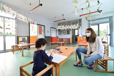 An educator speaks with one of the primary school children in one of three classes of 4-5 children each for primary school, two for kindergarten children, set up in the gym and in the playroom of Borgosesia owned by the Municipality, Borgosesia, 12 May 2020 A rightwing mayor in Piedmont has defied an education ministry ban on school openings in the coronavirus emergency by opening a school gym and play area to the young children of working parents who have no other way of taking care of their kids. Italy's schools are closed for the virus crisis until the start of the new school year in September. ANSA/ ALESSANDRO DI MARCO