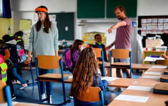 Teachers give instructions to their students in a classroom of the Petri primary school in Dortmund, western Germany, on June 15, 2020 amid the novel coronavirus COVID-19 pandemic. - From June 15, 2020, all children of primary school age in the western federal state of North Rhine-Westphalia will once again be attending regular daily classes until the summer holidays. The distance rules and compulsory mouthguards are no longer applicable. (Photo by Ina FASSBENDER / AFP) (Photo by INA FASSBENDER/AFP via Getty Images)