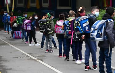 Students line up for the entrance at the schoolyard of the Petri primary school in Dortmund, western Germany, on June 15, 2020 amid the novel coronavirus COVID-19 pandemic. - From June 15, 2020, all children of primary school age in the western federal state of North Rhine-Westphalia will once again be attending regular daily classes until the summer holidays. The distance rules and compulsory mouthguards are no longer applicable. (Photo by Ina FASSBENDER / AFP) (Photo by INA FASSBENDER/AFP via Getty Images)