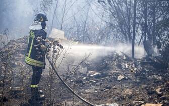 Maxi incendio sterpaglie a Roma, pompieri al lavoro Vigili del fuoco in azione, con l'aiuto di due autobotti, per spegnere il vasto incendio di sterpaglie divampato in zona Cornelia-Boccea a Roma, 14 luglio 2020. A quanto riferito dai pompieri, Ë stata interrotta la distribuzione di energia elettrica nel quadrante interessato dall'incendio per consentire lanci dall'alto con l'elicottero per spegnere le fiamme. ANSA / MASSIMO PERCOSSI