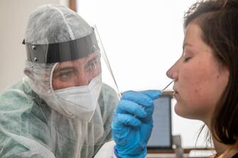 A health worker takes a swab sample from a woman to test for the COVID-19 coronavirus at the triage center 'Centrum' at the Sint-Vincentiusziekenhuis, in Antwerp on July 30, 2020. - The Covid-19 contamination numbers are on the rise, especially in the Antwerp city center. The National Security Council has announced more strict coronavirus measures, that went into effect yesterday, in an attempt to try and keep the contamination level as low as possible. (Photo by JONAS ROOSENS / Belga / AFP) / Belgium OUT (Photo by JONAS ROOSENS/Belga/AFP via Getty Images)