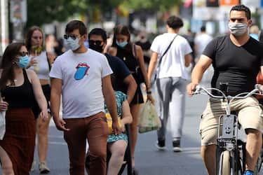 Cyclists and predestrians wear protective facemasks as they travel on a street in Antwerp on August 6, 2020, as authorities impose additional measures to attempt to curb the spread of the COVID-19 caused by the novel coronavirus". - The country with the highest number of deaths attributed to coronavirus compared to its population is Belgium with 85 fatalities per 100,000 inhabitants, followed by the UK at 68, Peru 61, Spain 61, and Italy 58. (Photo by FranÃ§ois WALSCHAERTS / AFP) (Photo by FRANCOIS WALSCHAERTS/AFP via Getty Images)
