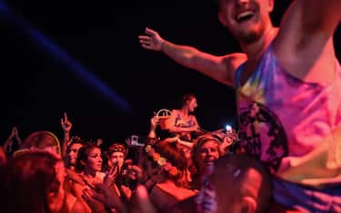 Partygoers dance on the beach during the Full Moon Party on Ko Phangan island in the southern Thai province of Surat Thani on the night of December 14, 2016.
Foreign tourists are returning in droves to the popular party island of Ko Phangan for the infamous Full Moon Party after restrictions on celebrations were eased months after the death of Thai King Bhumibol Adulyadej on October 13. / AFP / LILLIAN SUWANRUMPHA        (Photo credit should read LILLIAN SUWANRUMPHA/AFP via Getty Images)