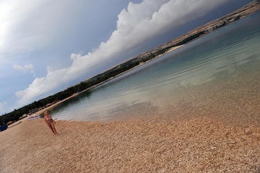 TO GO WITH AFP STORY by Lajla Veselica A woman walks on the Zrce beach on the Croatian island of Pag on June 27, 2009. Croatia is bracing for the peak of the summer season with hopes of avoiding a sharp downfall in its vital tourism sector, affected worldwide by the financial crisis.   AFP PHOTO/ HRVOJE POLAN (Photo credit should read HRVOJE POLAN/AFP via Getty Images)