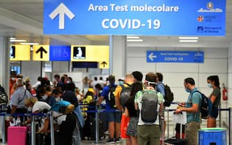 Passengers queue to be screened for Covid-19 at a testing station set up at Fiumicino airport, near Rome, on August 16, 2020. (Photo by Alberto PIZZOLI / AFP)