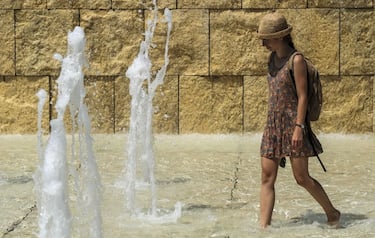 A woman cools herself in a fountain near the Ara Pacis monument, in central Rome on August 2, 2018. - Italy is experiencing its first summer heat wave with temperatures approaching 40 degrees Celsius. (Photo by Andreas SOLARO / AFP) (Photo by ANDREAS SOLARO/AFP via Getty Images)