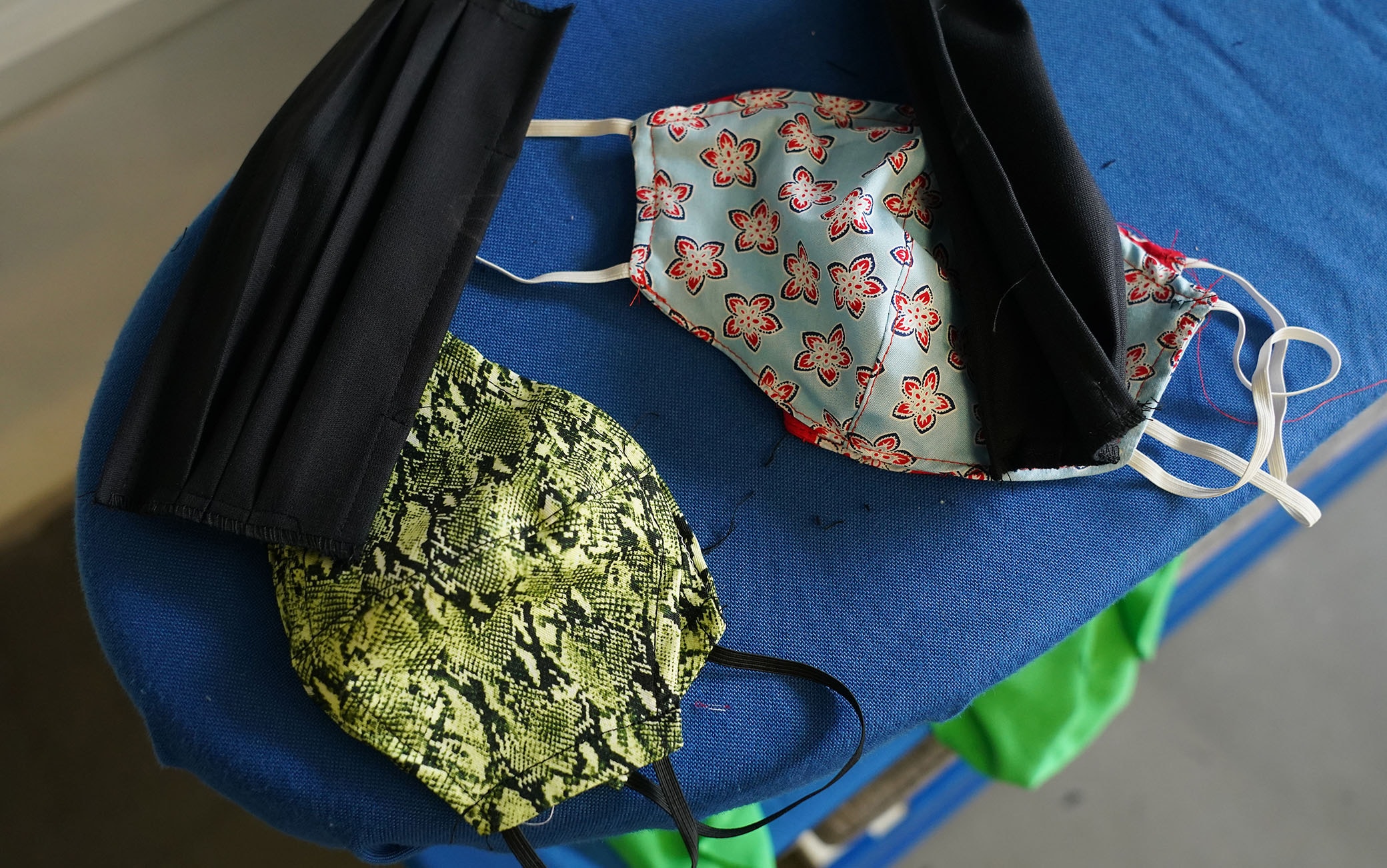 1216394644 BERLIN, GERMANY - APRIL 02: Made-to-order protective face masks lie on an ironing board at the workshop of master tailor Ala Hadye on April 02, 2020 in Berlin, Germany. Hadye, who has had to close her shop due to nationwide measures enacted to slow the spread of the coronavirus, says she is making 30 to 40 masks per week on custom order from her customers. "I could be making masks all week," she said, but says she turns large orders down and concentrates instead on her core customers. "There are so many others making masks", she says of other tailors she knows. Since her shop is closed she sends the masks to her customers by post rather than having them come to the shop. (Photo by Sean Gallup/Getty Images)