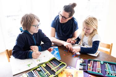 DINSLAKEN, GERMANY - MARCH 15: A mother helps her nine-year-old son and six-year-old daughter to do school homework on March 15, 2020 in Dinslaken, Germany. Schools, day care centers and universities are closing across Germany this week as the country grapples with the virus that so far has infected at least 5,800 people and killed 13. (Photo by Lars Baron/Getty Images)