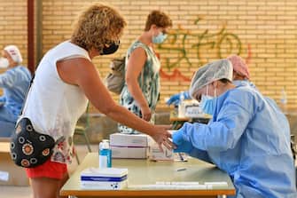 epa08641162 A health worker runs a quick coronavirus test on a teacher in Almeria, Spain, where hundreds of school teachers took the tests before the start of the school year, 02 Sepember 2020. A total of 13,500 teachers will be tested in Andalucia region before returning to the classrooms.  EPA/Carlos Barba