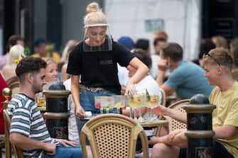 CARDIFF, WALES - AUGUST 08: A woman wearing a face visor serves drinks at Gin and Juice gin bar on August 08, 2020 in Cardiff, Wales. Coronavirus lockdown measures continue to be eased as the number of excess deaths in Wales falls below the five-year average. UK Prime Minister Boris Johnson has indicated he would force pubs, restaurants and shops to close ahead of schools in the event of severe coronavirus flare-ups. (Photo by Matthew Horwood/Getty Images)