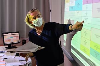 A teacher with a protective mask shows the weekly planning to pupils in a classroom in Brequigny high school in Rennes, western France, on September 1, 2020 on the first day of the school year amid the Covid-19 epidemic. - French pupils go back to school on September 1 as schools across Europe open their doors to greet returning pupils this month, nearly six months after the coronavirus outbreak forced them to close and despite rising infection rates across the continent. (Photo by Damien Meyer / AFP) (Photo by DAMIEN MEYER/AFP via Getty Images)