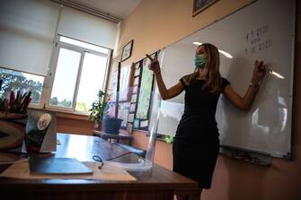 A teacher wearing a protective mask to prevent the spread of the novel coronavirus (covid-19), speaks to pupils in a classroom on the first day of the new school year in Belgrade on September 1, 2020. (Photo by Andrej ISAKOVIC / AFP) (Photo by ANDREJ ISAKOVIC/AFP via Getty Images)