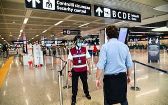 A Fiumicino airport employee wearing a "Smart-Helmet" portable thermoscanner to screen passengers and staff for COVID-19 (C), scans a fellow airport staff at boarding gates on May 5, 2020 at Rome's Fiumicino airport during the country's lockdown aimed at curbing the spread of the COVID-19 infection, caused by the novel coronavirus. (Photo by ANDREAS SOLARO / AFP) (Photo by ANDREAS SOLARO/AFP via Getty Images)