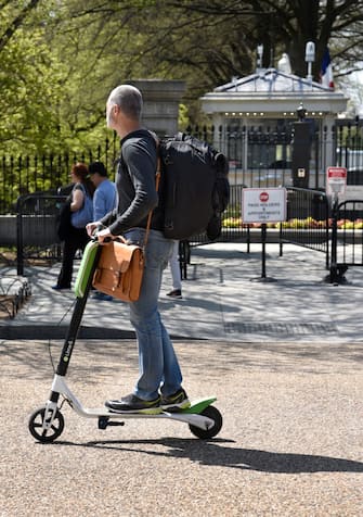WASHINGTON, D.C. - APRIL 22, 2018:  A man with a backpack rides his Lime-S electric scooter along Pennsylvania Avenue in front of the White House in Washington, D.C. (Photo by Robert Alexander/Getty Images)