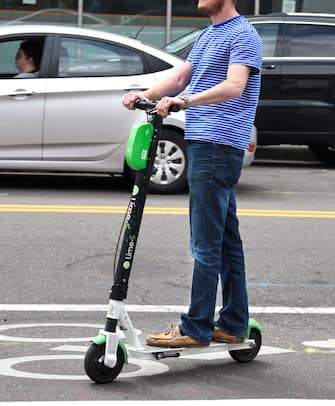 DENVER, COLORADO - AUGUST 30, 2019: A man rides a Lime electric scooter in downtown Denver, Colorado. (Photo by Robert Alexander/Getty Images)