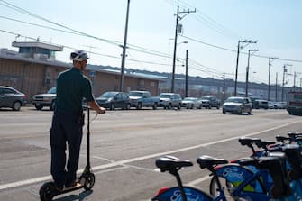Adult man wearing a bicycle helmet and commuting to work on a kick scooter in the South of Market (SoMa) neighborhood of San Francisco, California, October 13, 2017. (Photo by Smith Collection/Gado/Getty Images)