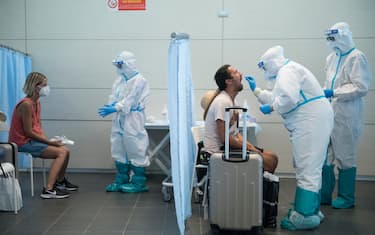 CASELLE TORINESE, ITALY - AUGUST 26: General view of medical staff in full PPE conduct a swab test on travellers after their flight from Ibiza, Spain to Turin on August 26, 2020 in Turin, Italy. At Italian airports, all travelers from countries at risk of Covid-19 are tested with swabs to prevent the spread of Covid 19 in Italy. (Photo by Stefano Guidi/Getty Images)