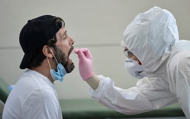 TURIN, ITALY - AUGUST 19: A man undergoes a swab test for Covid-19 at the testing site of Turin airport on August 19, 2020 in Turin, Italy. The Italian government is requiring people arriving from high-risk designated countries to take a Covid-19 test, which includes regions in Spain, Greece, Croatia and Malta. According to the Ministry of Health, Coronavirus infection rates are climbing again in Italy from an average of 400 new cases per day. Authorities see Italian returning from vacation abroad as a likely strong contributor to the uptick in infections. (Photo by Diego Puletto/Getty Images)