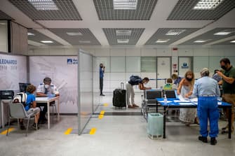 1228198724 ROME, ITALY - AUGUST 25: Passengers arriving from high-risk countries wait to carry out rapid antigenic tests for Covid-19 at a testing station set up inside Leonardo Da Vinci airport, on August 25, 2020 in Fiumicino, Rome, Italy. The region has introduced mandatory COVID-19 tests for anyone arriving from Croatia, Greece, Spain and Malta to avoid a spike of new cases. (Photo by Antonio Masiello/Getty Images)