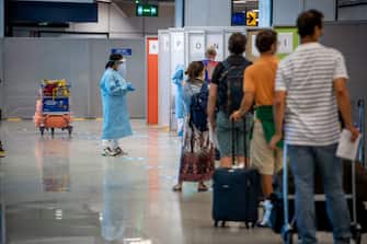 1228199049 ROME, ITALY - AUGUST 25: Passengers arriving from high-risk countries wait to carry out rapid antigenic tests for Covid-19 at a testing station set up inside Leonardo Da Vinci airport, on August 25, 2020 in Fiumicino, Rome, Italy. The region has introduced mandatory COVID-19 tests for anyone arriving from Croatia, Greece, Spain and Malta to avoid a spike of new cases. (Photo by Antonio Masiello/Getty Images)