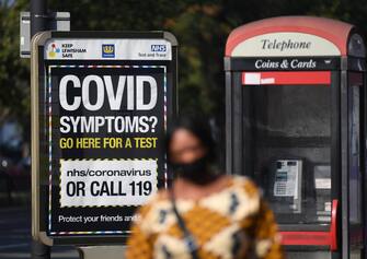 epa08670851 Pedestrians walk past a sign displaying a Covid helpline in London, Britain, 15 September 2020. In order to curb the rise in coronavirus cases in the UK, it is now illegal for groups of more than six to meet up. The 'rule of six' have been implemented in the latest push to curb the recent surge in coronavirus infections in the United Kingdom.  EPA/FACUNDO ARRIZABALAGA