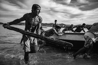 At the first light of day, some fishermen are seen returning to the beach after spending the night at sea. Itaipu Beach, Rio de Janeiro, Brazil - 05/06/2017 - The artisanal fishery in Guanabara Bay is a very old practice and represents a true heritage of traditions and culture. It has its origins in indigenous, Portuguese and Spanish techniques both in navigation aspects and in the production of its vessels and nets.

