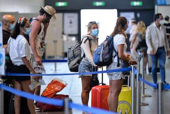 TURIN, ITALY - AUGUST 19: Passengers wait to show documents for Covid-19 test in the Turin airport on August 19, 2020 in Turin, Italy. The Italian government is requiring people arriving from high-risk designated nations to take a Covid test. This includes regions in Spain, Greece, Croatia and Malta. According to the ministry of health, Coronavirus infection rates are climbing again in Italy from an average of 400 new cases per day. Authorities see Italian returning from vacation abroad as a likely strong contributor to the uptick in infections. (Photo by Diego Puletto/Getty Images) (Photo by Diego Puletto/Getty Images,)