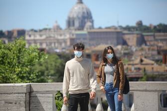 Roma, Italy, 4 maggio 2020: Una giovane coppia sulla terrazza del gianicolo con le mascherine nel giorno di inizio della fase 2 dopo circa 2 mesi dallâ  inizio della quarantena per contrastare la diffusione del virus Covid-19. Nel centro storico di Roma ha riaperto villa Borghese per consentire attivitÃ  fisica allâ  aperto. Non sono molte le persone che si trovano in giro. (MARCO IACOBUCCI / IPA/Fotogramma, ROMA - 2020-05-04) p.s. la foto e' utilizzabile nel rispetto del contesto in cui e' stata scattata, e senza intento diffamatorio del decoro delle persone rappresentate