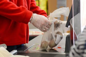 ROME, ITALY - MAY 06: A Cashier at a supermarket works while wearing a gloves as a preventive measure during the Coronavirus (COVID-19) crisis on May 06, 2020 in Rome, Italy. Italy was the first country to impose a nationwide lockdown to stem the transmission of the Coronavirus (Covid-19), and its restaurants, theaters and many other businesses remain closed. (Photo by Silvia Lore/Getty Images)