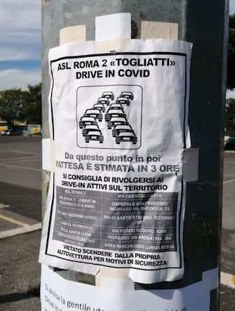 Un cartello attaccato ad un palo della strada sulla Palmiro Togliatti annuncia le lunghe code per accedere al Drive-in ed effettuare il tampone per il Coronavirus, Roma, 6 ottobre 2020. L'attesa è di 4-5 ore. ANSA