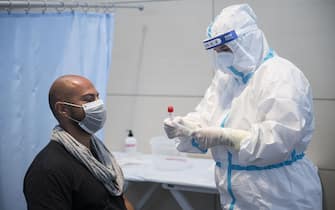 CASELLE TORINESE, ITALY - AUGUST 26: Medical staff in full PPE using swabs test on man on August 26, 2020 in Turin, Italy. At Italian airports, all travelers from countries at risk of Covid-19 are tested with swabs to prevent the spread of Covid 19 in Italy. (Photo by Stefano Guidi/Getty Images)